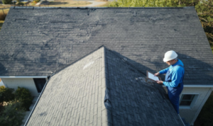 How can noticing small piles of roofing material in gutters warn you about wear and tear