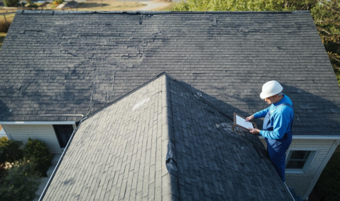 How can noticing small piles of roofing material in gutters warn you about wear and tear