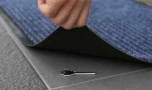 Why is it risky to leave spare keys under mats or in obvious hiding spots